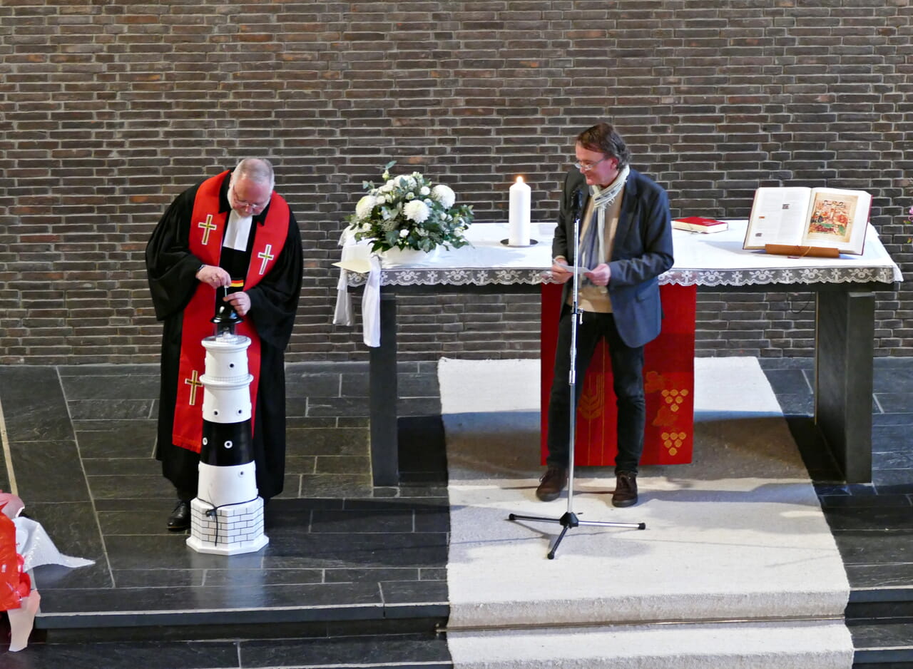 Dirk Hermann dankt Armin Pulfrich und überreicht einen großen Leuchtturm.